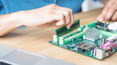 it-technician-repairing-hardware-equipment-s-wooden-table